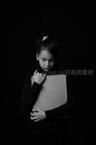 黑衣女孩怀抱相册凝视