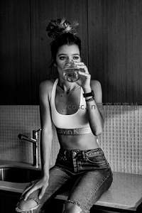 厨房台面上喝水的时尚女孩