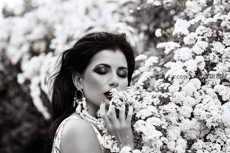 花丛中嗅香的优雅女子