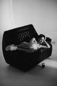 慵懒女子躺卧皮质沙发休憩