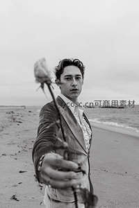 海滩上递出玫瑰的男子