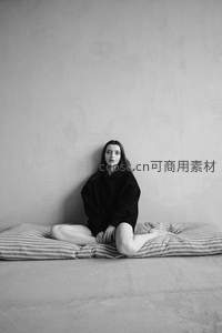 女子盘腿坐于条纹垫上凝视镜头