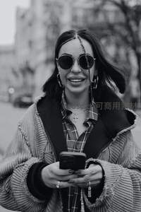 街头时尚女孩手持手机微笑