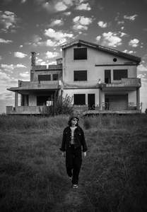 荒草丛中少年走向废弃老宅背影