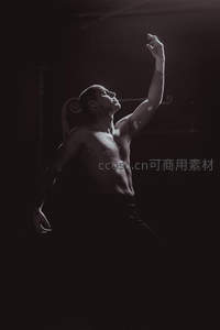 舞者光影中舒展，肌肉线条尽显力量美