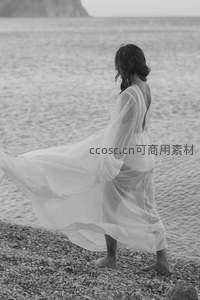 背影漫步海岸，裙裾随风飞扬