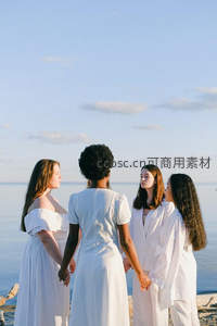 四位女性海边牵手，白衣飘逸共赏海天一色