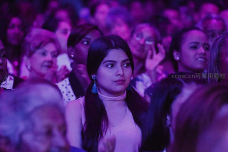紫色灯光下专注观演女子