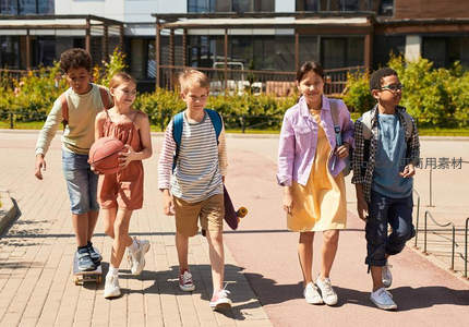 阳光下孩童结伴欢笑前行