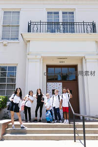 孩子们在白色建筑前台阶上开心合影