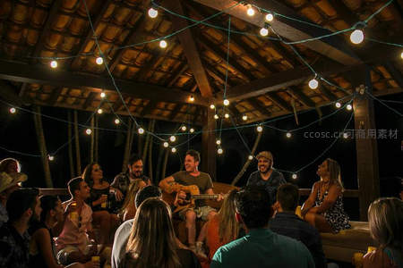 夜晚灯光下朋友们围坐听吉他弹唱