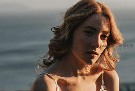 海边夕阳下的沉思女子