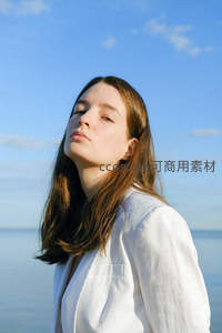 白衣女子面朝蓝天闭目