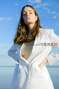 白西装女子海边叉腰站立