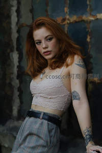 红发少女倚墙，蕾丝上衣与纹身点缀