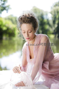 湖畔粉裙女子执羽毛书卷静读