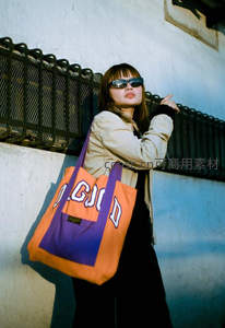 墙边酷感女孩手提彩色包