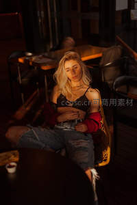 咖啡馆中金发女郎，暖光下慵懒迷人