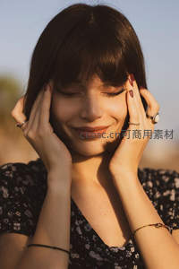 阳光下微笑女子闭眼享受