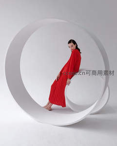 红裙女子坐于白色环形装置