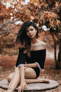 秋日林间卷发少女静坐石凳