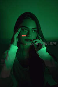 绿光笼罩下女子面颊映焦虑