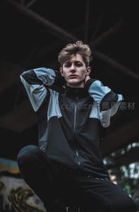 酷帅少年蹲坐桥下，黑白拼接夹克吸睛
