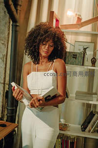 卷发女子专注阅读书籍