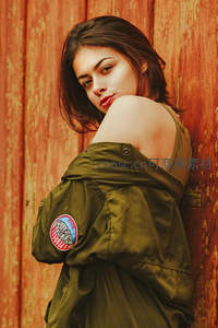 绿衣少女倚靠锈墙凝视镜头