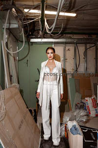 白色西装套装女性站立废弃仓库中