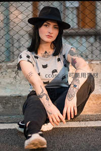 纹身少女戴帽坐阶前
