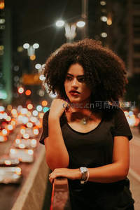 夜色霓虹下卷发女子凝望镜头