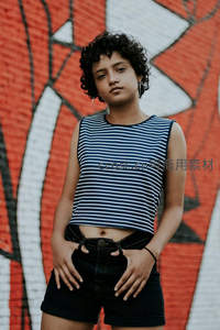 涂鸦墙前短发少女自信站立