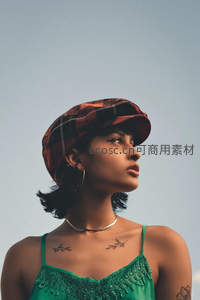 戴格纹帽女子仰望天空颈部有纹身
