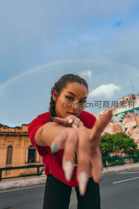 彩虹下红衣女伸手指向镜头