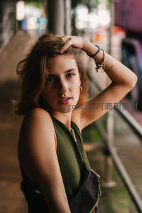 街头巷尾绿衣少女手抚秀发，温柔回望