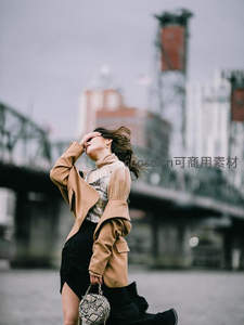 城市街头风衣女郎，桥下仰望天空姿态洒脱