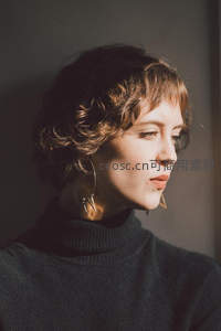 侧脸光影中的卷发女子沉思