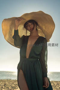 海滩宽檐帽女郎，绿裙迎风优雅伫立