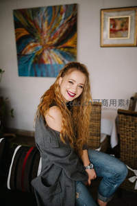 卷发美女在艺术画廊中绽放笑容