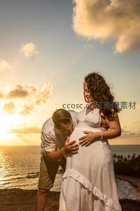 夕阳海岸孕妈与伴侣温馨相拥