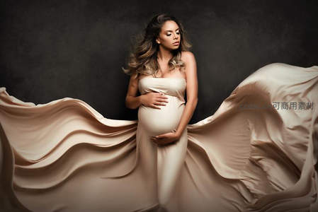 暗调背景下流动布料中的温柔孕妈
