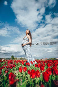花海中孕妇享受春日暖阳