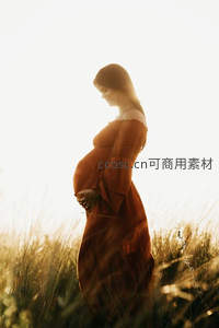 夕阳下的准妈妈温柔凝望孕肚