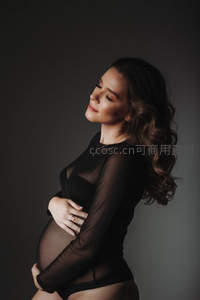 侧颜微笑的准妈妈，黑色透视装显优雅