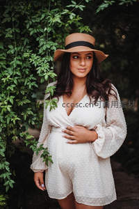 林间孕妈优雅伫立，手抚腹部
