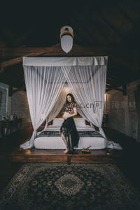 纱幔床前孕妇静坐，复古民宿风情