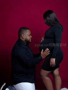 丈夫跪地轻抚妻子孕肚温馨时刻