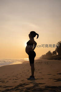 夕阳沙滩剪影，孕妈静享海边宁静时光