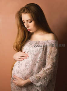 柔光下凝视孕肚的女子